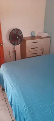a bedroom with a bed and a desk with a fan at Casa a solo 20 minutos aproximadamente de Manuel Antonio Beach y a 10 minutos aproximadamente del centro de Quepos in Quepos
