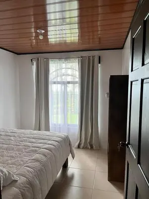 a bedroom with a bed and a window at House view of the sunrise, 4 rooms in San Gerardo