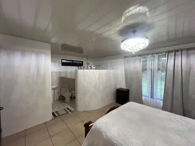 a bedroom with a bed and a bathroom with a toilet at House view of the sunrise, 4 rooms in San Gerardo