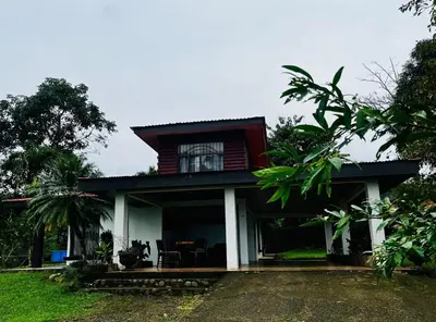 a house with a red roof with a table in front of it at House view of the sunrise, 4 rooms in San Gerardo