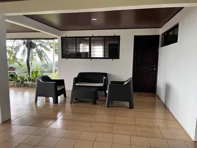 a living room with chairs and a table and a door at House view of the sunrise, 4 rooms in San Gerardo