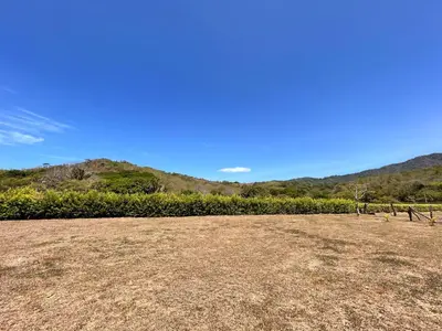 an empty field with a mountain in the background at Cabañas Corozalito in Corozalito