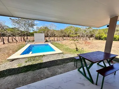 a patio with a table and a swimming pool at Cabañas Corozalito in Corozalito