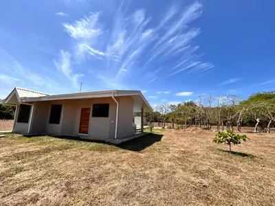 a small house in a field with a blue sky at Cabañas Corozalito in Corozalito