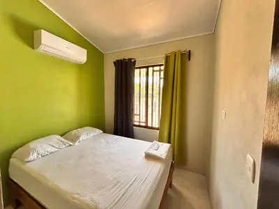 a small bedroom with a bed and a window at Cabañas Corozalito in Corozalito