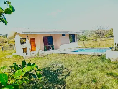 a small house with a swimming pool in the yard at Cabañas Corozalito in Corozalito