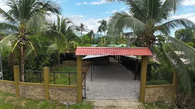 a building with a red awning and palm trees at Las Palmeritas de Ojochal in Tortugal