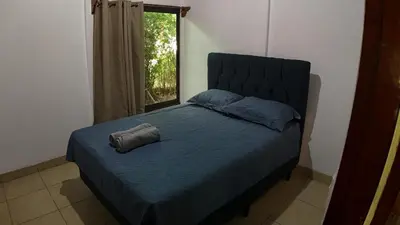 a bedroom with a bed with a pillow and a window at Las Palmeritas de Ojochal in Tortugal