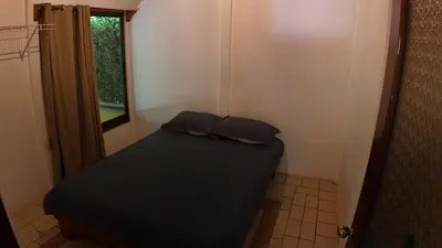 a small bedroom with a bed and a window at Las Palmeritas de Ojochal in Tortugal