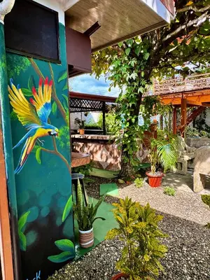 a colorful bird painted on the side of a building at Villas Ela en Bahía Ballena Uvita hermosas habitaciones privadas grandes, piscina, cocina, jacuzzi, aire acondicionado, tv, baño privado, parqueo gratis y terraza in Uvita