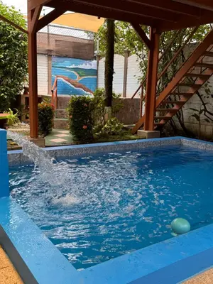 a swimming pool with water spraying into the air at Villas Ela en Bahía Ballena Uvita hermosas habitaciones privadas grandes, piscina, cocina, jacuzzi, aire acondicionado, tv, baño privado, parqueo gratis y terraza in Uvita
