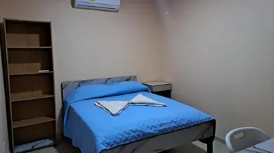 a bedroom with a blue bed with towels on it at Hospedaje Arboleda in Quepos