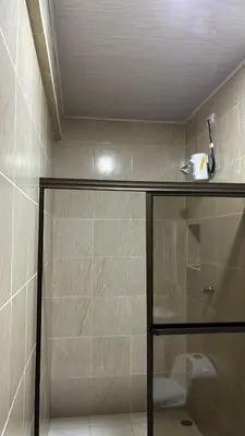 a bathroom with a shower with a sink and a toilet at Hospedaje Arboleda in Quepos