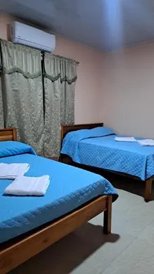 a bedroom with two beds and a window at Hospedaje Arboleda in Quepos
