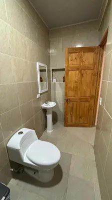 a bathroom with a toilet and a sink at Hospedaje Arboleda in Quepos