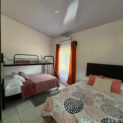 a bedroom with two bunk beds and a window at Casa Celeste Río Grande in Paquera