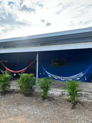 a blue building with a hammock in front of it at Casa Celeste Río Grande in Paquera