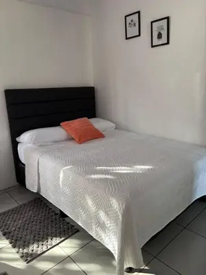a bed with a black and white comforter on it at Casa Celeste Río Grande in Paquera