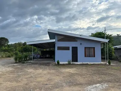 a small white house with a large yard at Casa Celeste Río Grande in Paquera