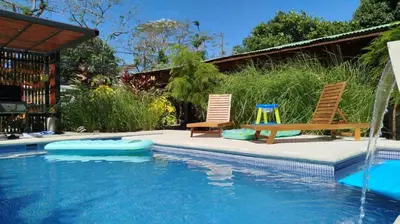 a pool with two chairs and a table and a swing at 16 minutes from Tamarindo in Portegolpe