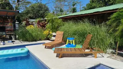 two chairs and a table next to a swimming pool at 16 minutes from Tamarindo in Portegolpe