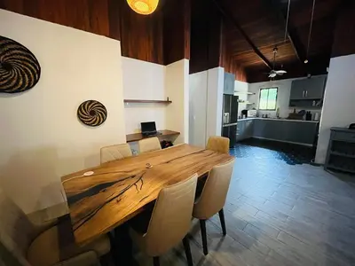 a wooden table and chairs in a room with a kitchen at 16 minutes from Tamarindo in Portegolpe