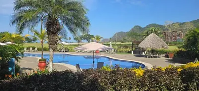a resort pool with a palm tree and tables and chairs at CR Luxury Del Mar 2Q 3 Bdrm in La Mona