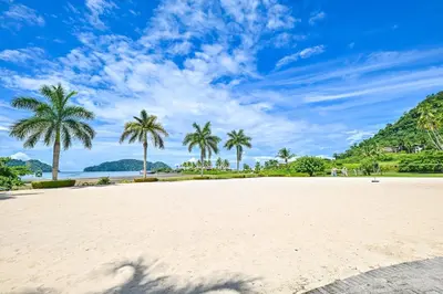 a sandy beach with palm trees in the background at CR Luxury Del Mar 2Q 3 Bdrm in La Mona