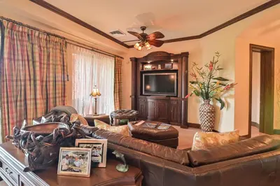 a living room with a leather couch and a television at CR Luxury Montebello 3F 3 Bdrm in Jacó
