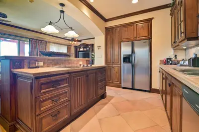a kitchen with wooden cabinets and a stainless steel refrigerator at CR Luxury Montebello 3F 3 Bdrm in Jacó