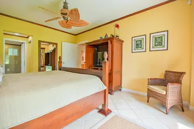 a bedroom with a bed and a fan and a chair at CR Luxury Del Mar 4Q 2 Bdrm in La Mona