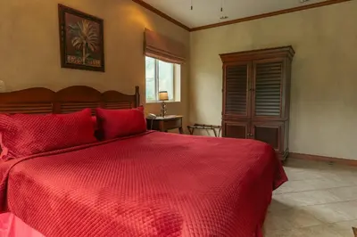 a bedroom with a red bed with a red comforter at CR Luxury Veranda 7B 2 Bdrm in La Mona