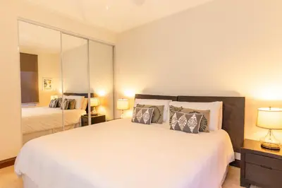 a bedroom with a large white bed with two lamps at CR Luxury Altavista 2B 3 Bdrm in La Mona