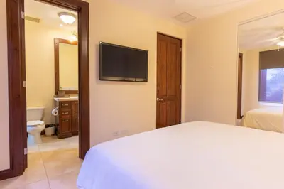 a bedroom with a bed and a television on a wall at CR Luxury Altavista 2B 3 Bdrm in La Mona