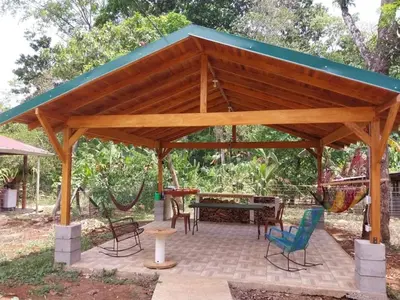 a wooden pavilion with chairs and a table at Cabaña Tiquisia in San Lorenzo