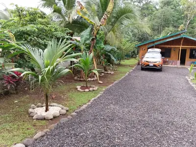a car parked in front of a house with palm trees at Cabaña Tiquisia in San Lorenzo