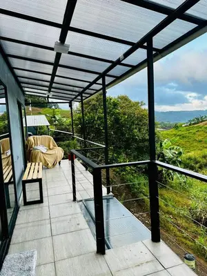 a screened in porch with a bench and a couch at Casa Money in Turrialba
