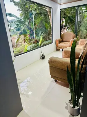 a living room with a couch and a large window at Casa Money in Turrialba
