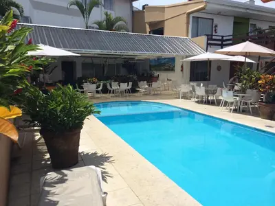 a swimming pool with chairs and tables and umbrellas at Hotel Residence Inn Suites Cristina in San José