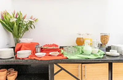 a table with plates and other dishes on it at Hotel Residence Inn Suites Cristina in San José