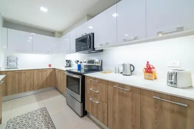 a kitchen with wooden cabinets and stainless steel appliances at CR Luxury La Estancia Floresta #05 3 Bdrm in La Mona