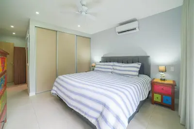 a bedroom with a bed with a striped blanket at CR Luxury La Estancia Floresta #05 3 Bdrm in La Mona