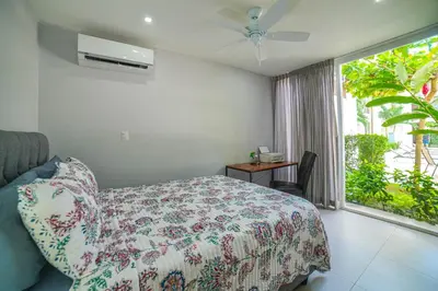 a bedroom with a bed and a window with a fan at CR Luxury La Estancia Floresta #05 3 Bdrm in La Mona