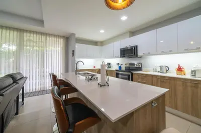 a kitchen with a white counter top and wooden cabinets at CR Luxury La Estancia Floresta #05 3 Bdrm in La Mona