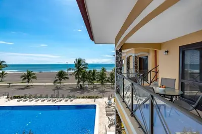 a view of the beach from the balcony of a house at JACO HEAVEN Beachfront Penthouse in Jacó