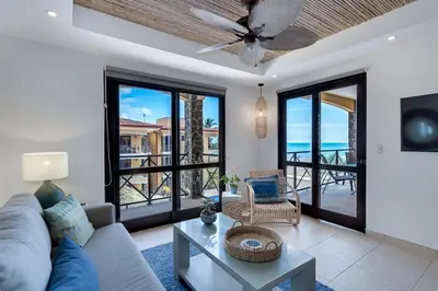 a living room with a couch and a ceiling fan at JACO HEAVEN Beachfront Penthouse in Jacó