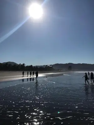 a group of people walking on the beach at JACO HEAVEN Beachfront Penthouse in Jacó