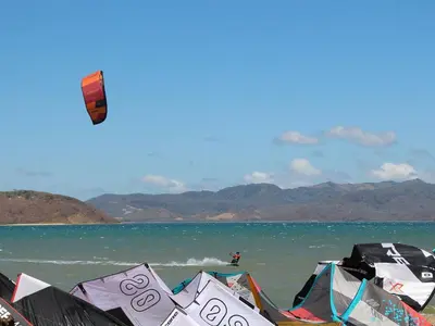 a kite is flying over the water on a beach at Kite Bungalow Bahia Salinas in La Cruz