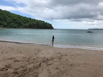 a person standing on a beach near the water at Kite Bungalow Bahia Salinas in La Cruz