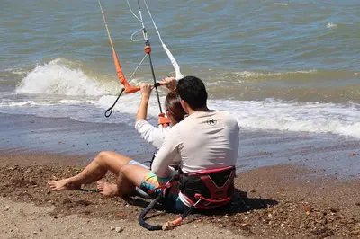 a man and a woman sitting on the beach at Kite Bungalow Bahia Salinas in La Cruz